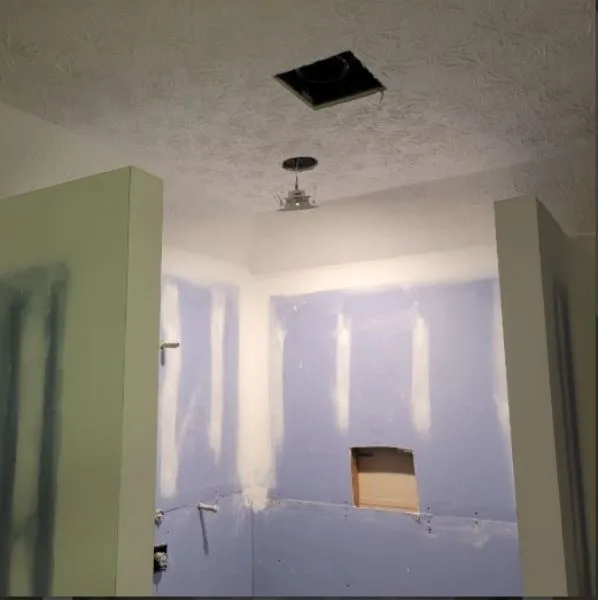 Professional drywall contractor patching a water-damaged ceiling with seamless texture matching in Henry County, GA